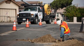 A San Diego Gas & Electric worker digs to access an underground line in this undated photograph.