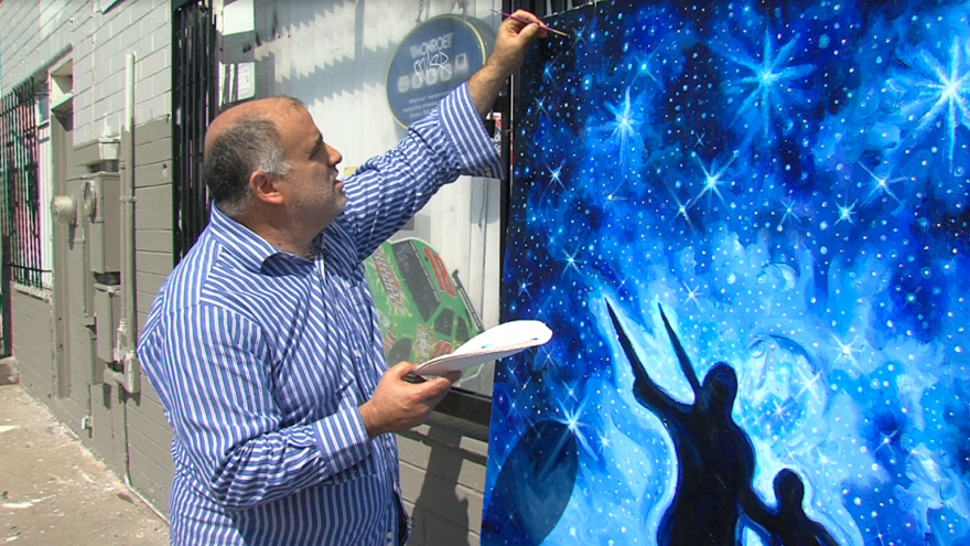 Michael Rosenblatt, muralist, works on his nautical twilight painting, which he donated to Imperial Avenue Auto Service, March 9, 2017.