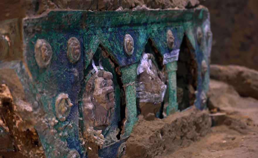 An ornate ceremonial chariot recently discovered in the ruins of Pompeii, decorated with bronze and tin medallions on the sides and rear.