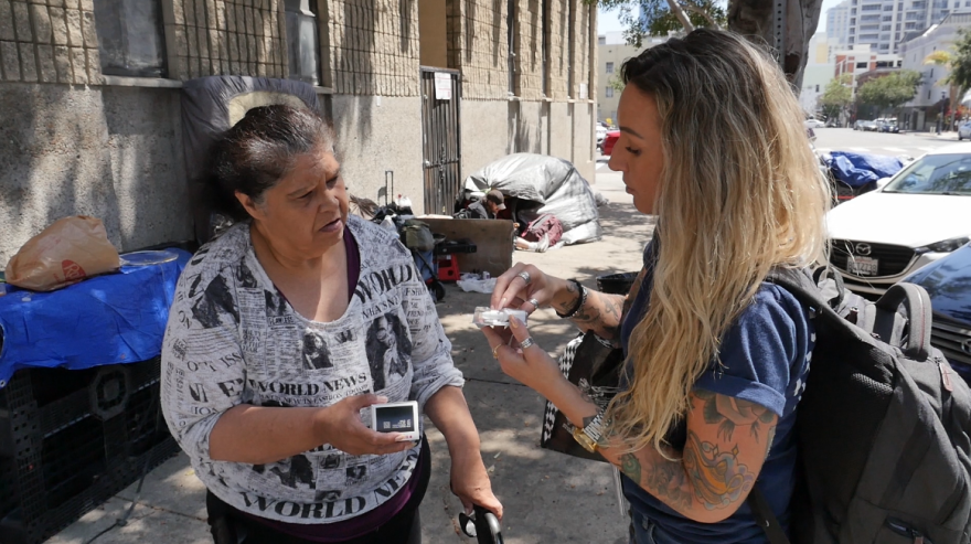 Father Joe's Villages Street Health Team supervisor Jennifer Wilkens shows an unsheltered resident how to use Narcan in downtown San Diego on Aug. 1, 2023.