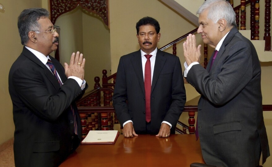 In this photograph provided by the Sri Lankan President's Office, interim President Ranil Wickremesinghe, right, greets Chief Justice Jayantha Jayasuriya during the oath-taking ceremony in Colombo, Sri Lanka, on Friday.