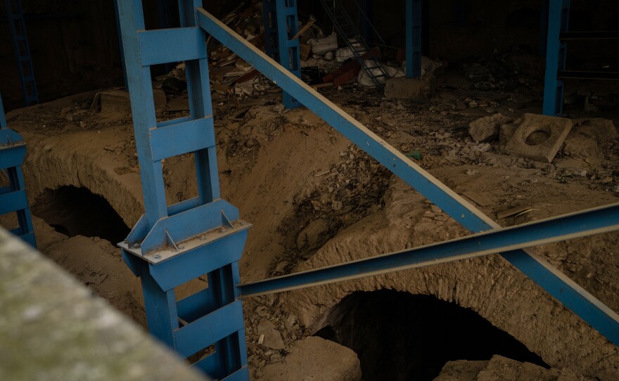Scaffolding is attached to 6th century archways surrounded by garbage.