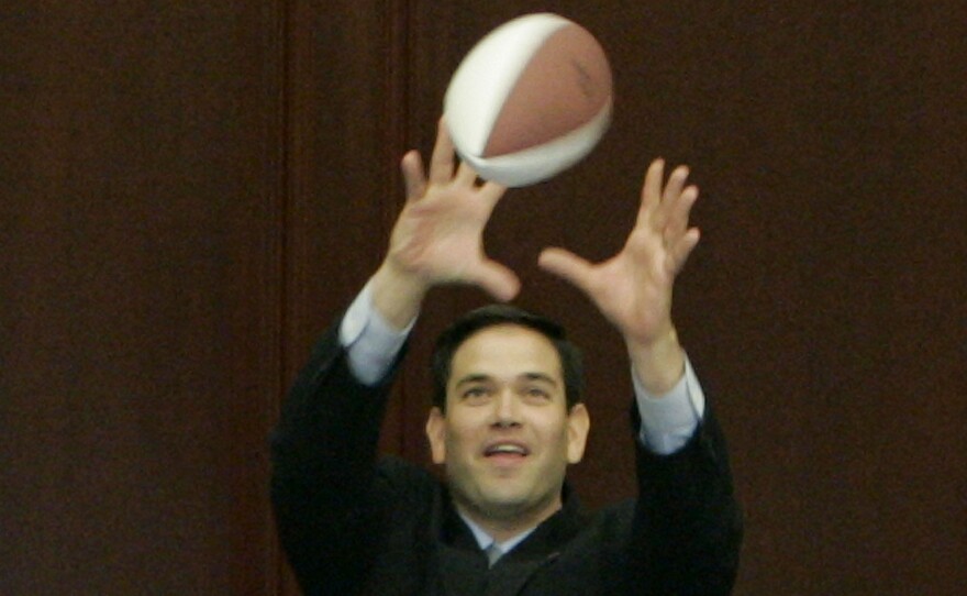 Rubio, who went to college on a football scholarship, catches a pass from University of Florida quarterback Chris Leak during Leak's visit to Florida's House of Representative in 2007.