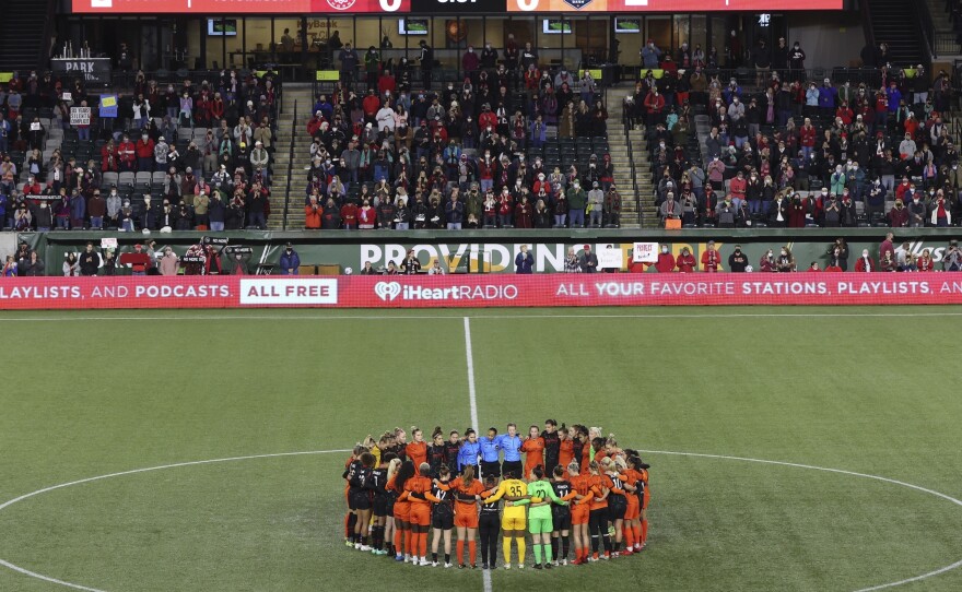 Portland Thorns and Houston Dash players, along with referees, gather at midfield, in demonstration of solidarity with two former NWSL players who came forward with allegations of sexual harassment and misconduct against a prominent coach, during an NWSL soccer match in Portland, Ore., Oct. 6, 2021.