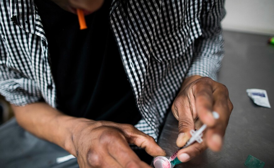 A drug user prepares to inject himself with heroin inside VANDU's supervised injection room.