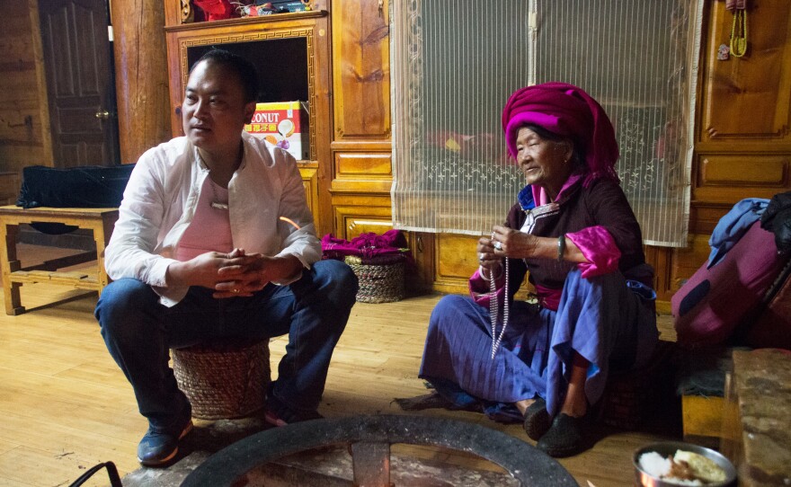 Zhaba Songding and his maternal grandmother Ani Ciru warm themselves by the hearth in their traditional living room, known in Mosuo culture as a "grandmother's room."