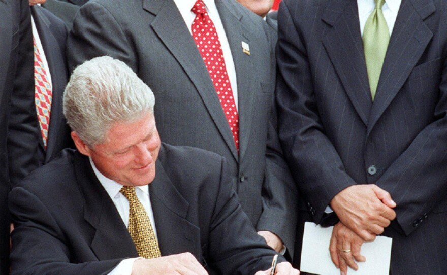 Gingrich stands with then-Republican Rep. John Kasich of Ohio while President Clinton signs the balanced-budget agreement in August 1997.