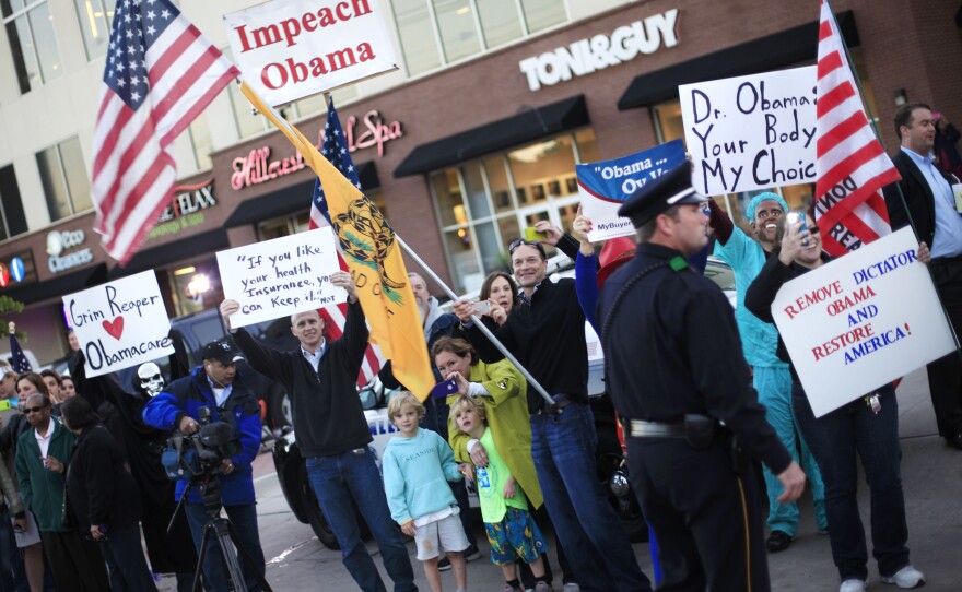 People protest President Obama's "If you like your insurance you can keep it" comment during a presidential visit to Dallas last week.