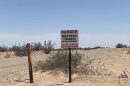 A sign near the MV-22B Osprey crash site in Glamis, California, reads "Danger. Military Training In Progres. Do Not Enter," June 8, 2022.