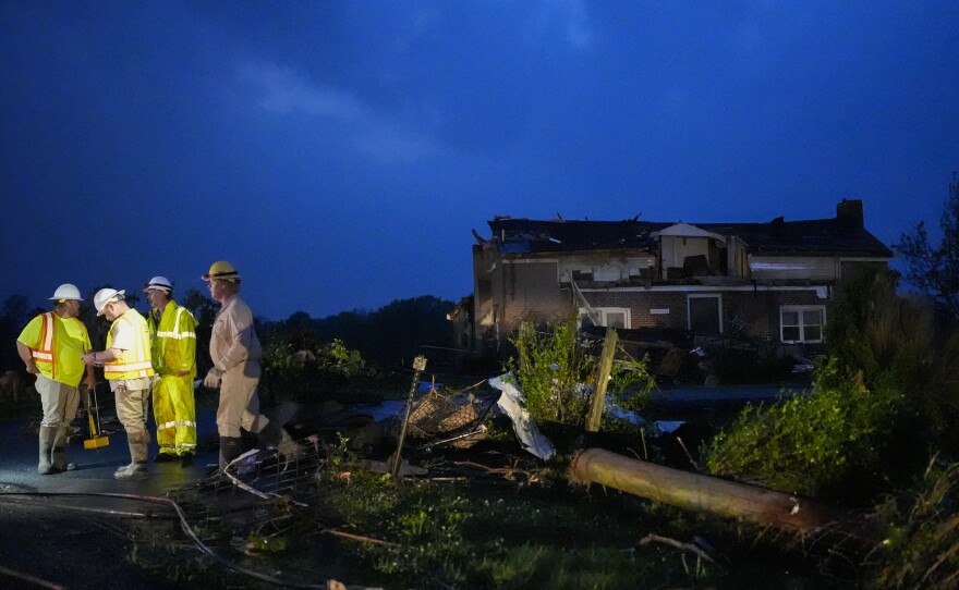 Utility workers survey storm damage along Cothran Road on Wednesday in Columbia, Tenn.