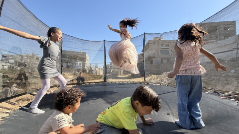 Palestinian children leap into the air while playing on a trampoline in northern Gaza's militarized orange zone of Beit Lahia, on May 31.