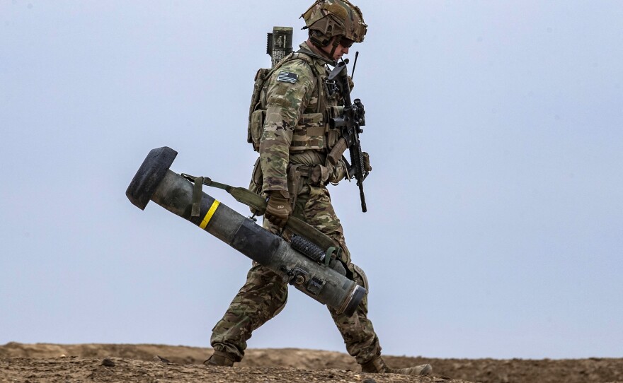 A U.S. soldier walks with a Javelin surface-to-air missile launcher in the countryside of Deir Ezzor in northeastern Syria in December 2021.