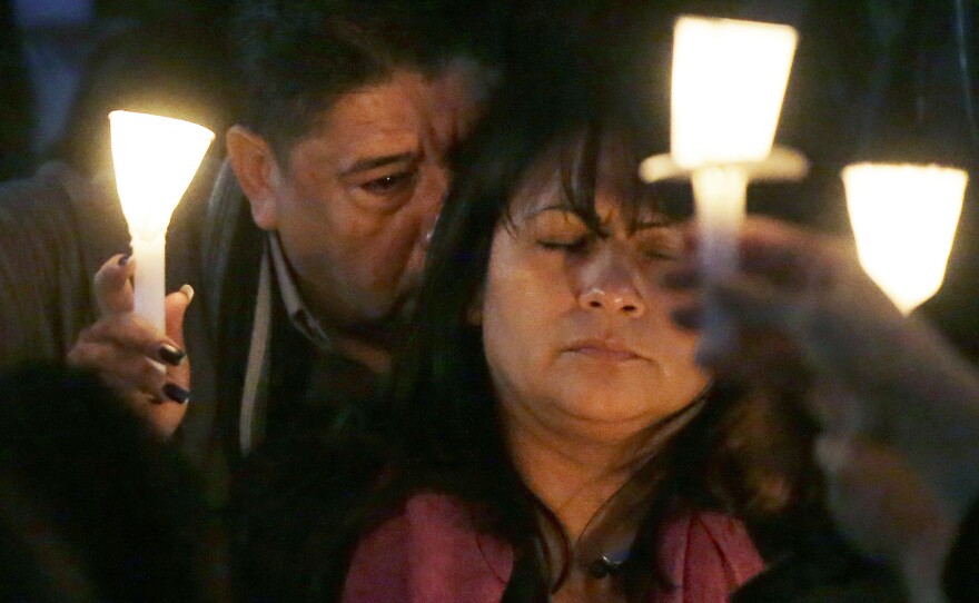 Beatriz Gonzalez, mother of Nohemi Gonzalez, holds up a candle with Nohemi's step-father Jose Hernandez during a memorial service on Sunday, in Long Beach, Calif. Gonzalez was killed at restaurant in Paris on Friday night during the terrorist attacks.