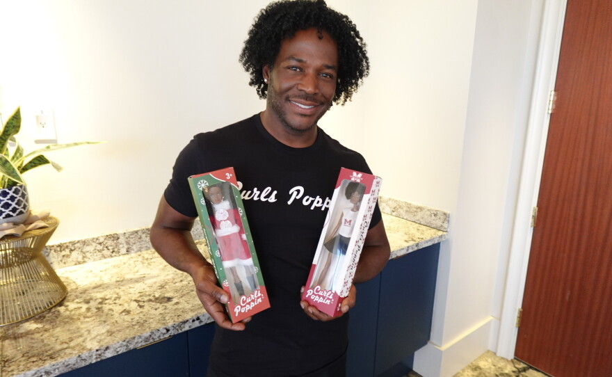 Curls Poppin' CEO Ashley Head holds two Curls Poppin' dolls on Sept. 22, 2026, at the University Club of San Diego.