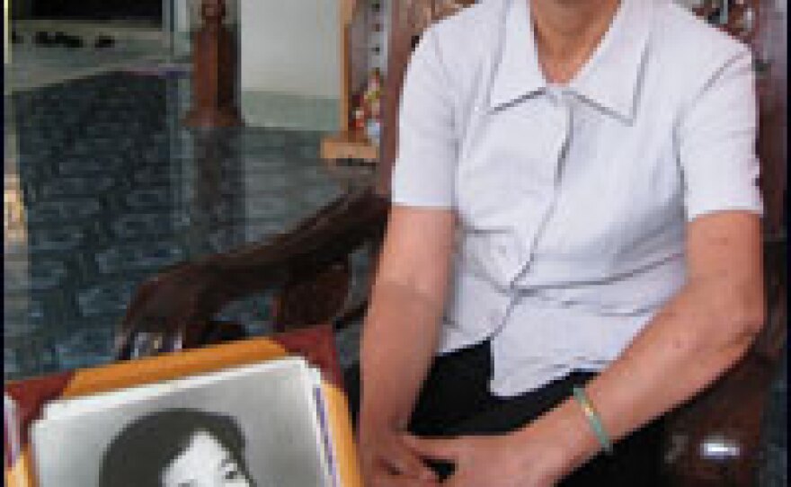 Vu Minh Nghia sits in her home in Ho Chi Minh City, formerly Saigon. Nghia was one of 15 Viet Cong assigned to attack the Presidential Palace in Saigon at the beginning of the Tet Offensive on Jan. 31, 1968. In the frame, a photo of Nghia from 1967.