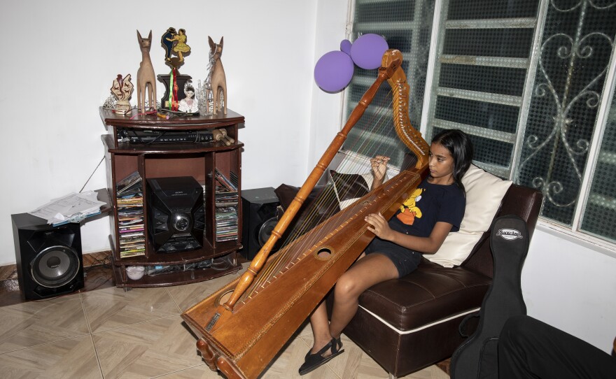 Mariangel playing harp at home, rehearsing for a contest in Valledupar, in 2022.