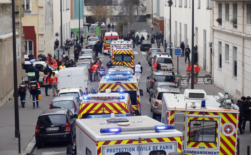 Ambulances gather in the street outside the Charlie Hebdo office in Paris. Hollande promised that "everything will be done to capture the perpetrators" and bring the gunmen to justice.
