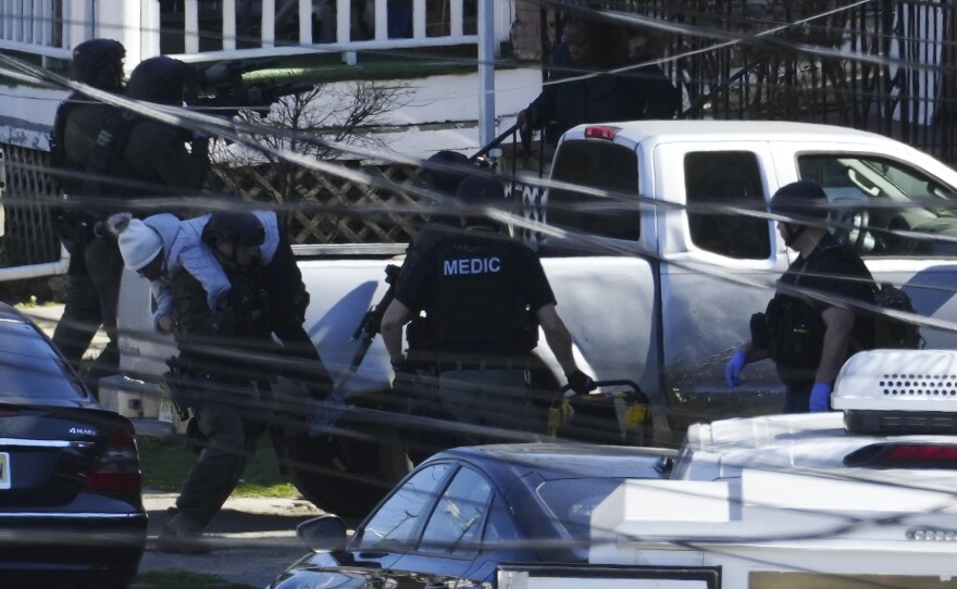 A resident is evacuated from a home in Trenton, N.J. on Saturday.