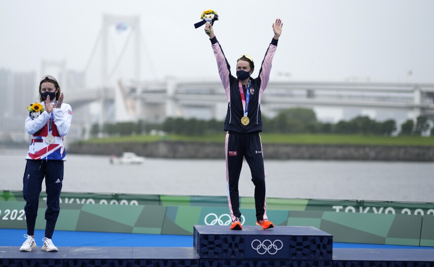 Gold medal winner Flora Duffy of Bermuda (center) celebrates her win in the triathlon on Tuesday, next to silver medalist Georgia Taylor-Brown of Great Britain.