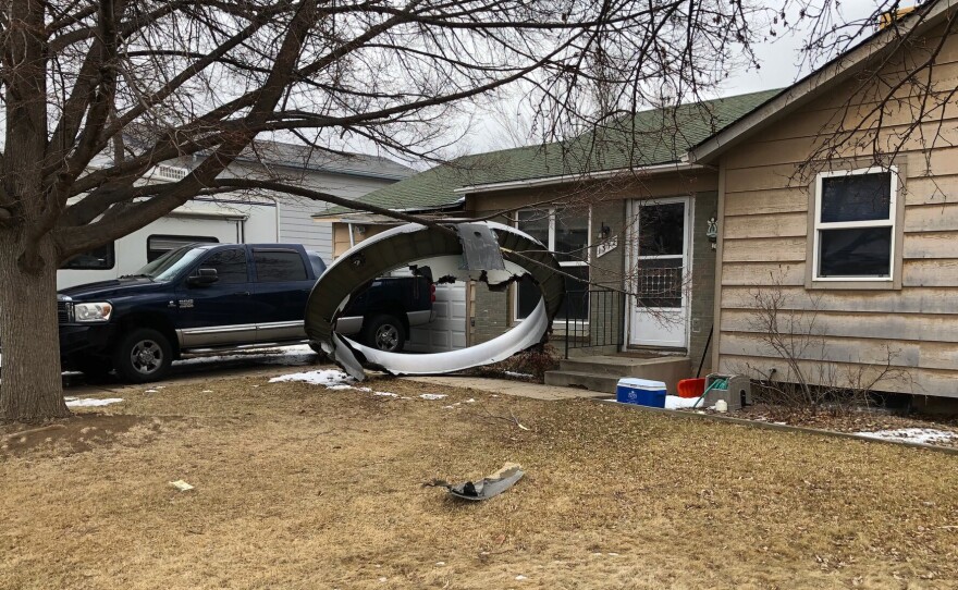 Debris is scattered in the front yard of a house in Broomfield, Colo., Saturday. A commercial airliner dropped debris in Colorado neighborhoods during an emergency landing Saturday.