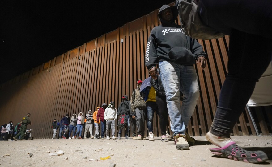 A group of migrants, mostly from Cuba, line up to board a bus after crossing the border from Mexico and surrendering to authorities to apply for asylum on Thursday, Nov. 3, 2022, near Yuma, Arizona.