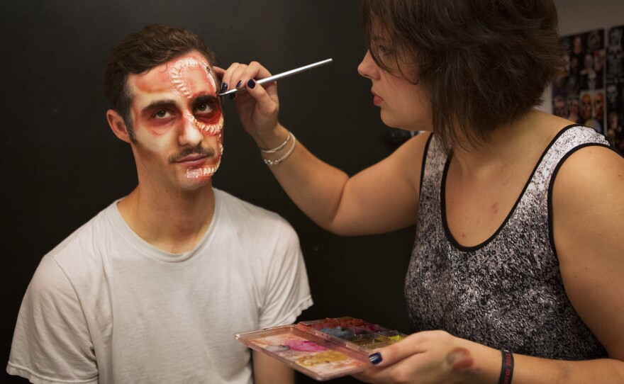 At one of 14 makeup stations, Nickki Duban works on Josh Rothstein's stitches. All of the masks are created in house and the makeup artists hang images of gruesome injuries and half-human creatures for inspiration.