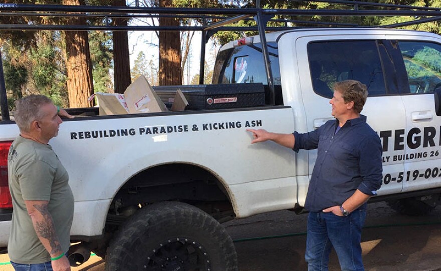 THIS OLD HOUSE host Kevin O'Connor (right) stands next to a workman's truck with a decal that reads "Rebuilding Paradise & Kicking Ash."