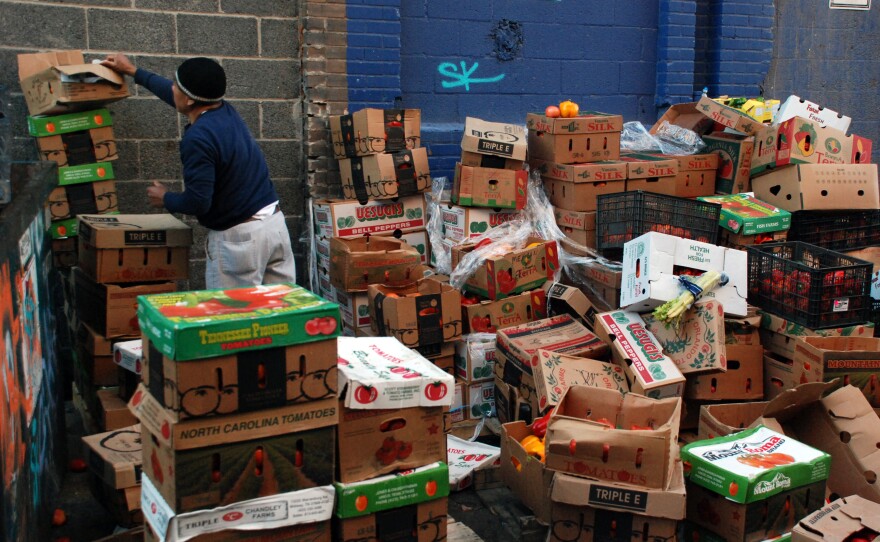 Boxes of unsold produce sit stacked outside Mexican Fruits, a discount grocer. A few loads will be donated to churches but the rest will be thrown away.