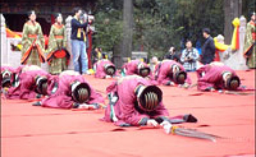 Attendants perform ritual prostrations at Confucius' birthplace in Qufu.