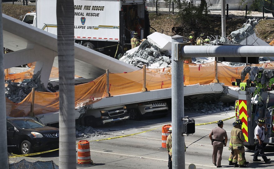 Vehicles are seen trapped under a collapsed pedestrian bridge Thursday near Florida International University in Miami.