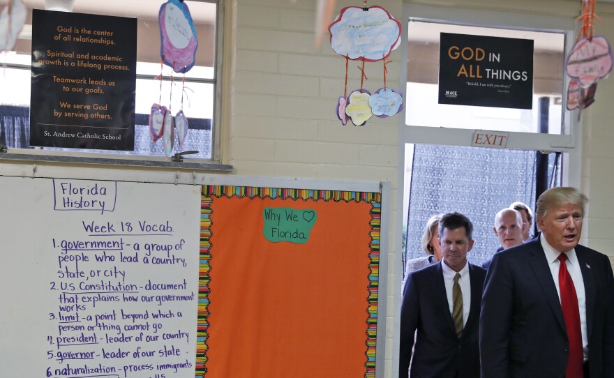 President Donald Trump enters Jane Jones' fourth grade class during a tour of Saint Andrew Catholic School in Orlando, Fla.