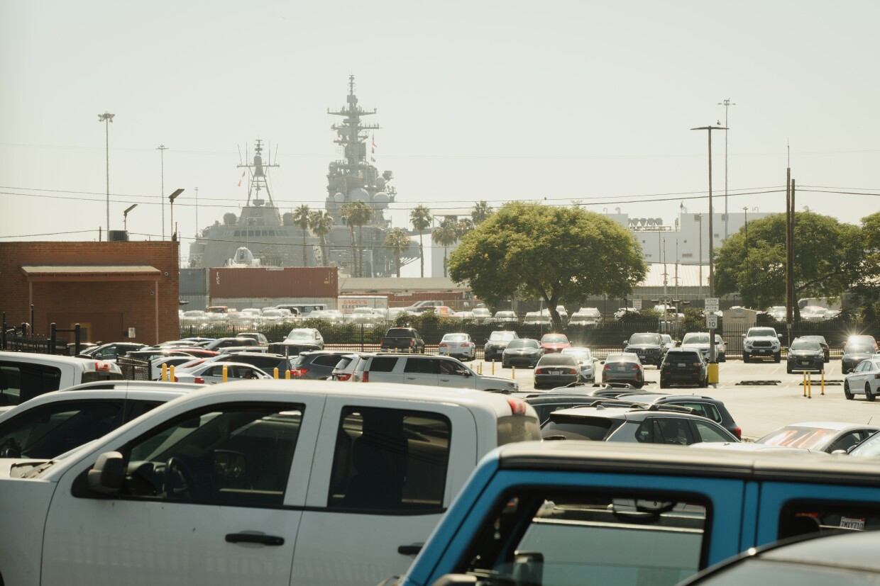 Ships docked along the bayfront rise over a parking lot of cars near the Port of San Diego in National City, California on July 10, 2025.