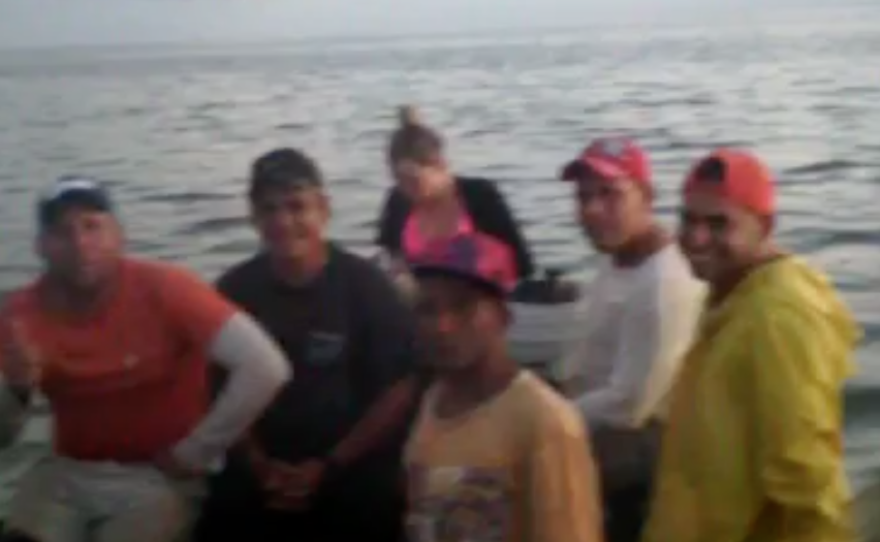 A screenshot of a video showing a portion of the 14 Cubans packed into a small wooden boat heading to Florida.