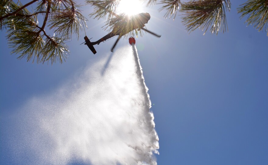 New Mexico National Guard Aviation soldiers execute water drops as part of firefighting efforts, dropping thousands of gallons of water on the Calf Canyon/Hermits Peak fire in northern New Mexico on Sunday.