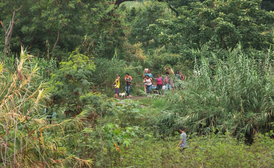 People walk into Colombia through an illegal crossing near the Simón Bolívar bridge.