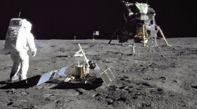 Astronaut Edwin E."Buzz" Aldrin Jr., Lunar Module pilot, is photographed during the Apollo 11 extravehicular activity on the Moon. He has just deployed the Early Apollo Scientific Experiments Package (EASEP). In the foreground is the Passive Seismic Experiment Package (PSEP); beyond it is the Laser Ranging Retro-Reflector (LR-3); in the center background is the United States flag; in the left background is the black and white lunar surface television camera; in the far right background is the Lunar Module "Eagle". Astronaut Neil A. Armstrong, commander, took this photograph with a 70mm lunar surface camera.