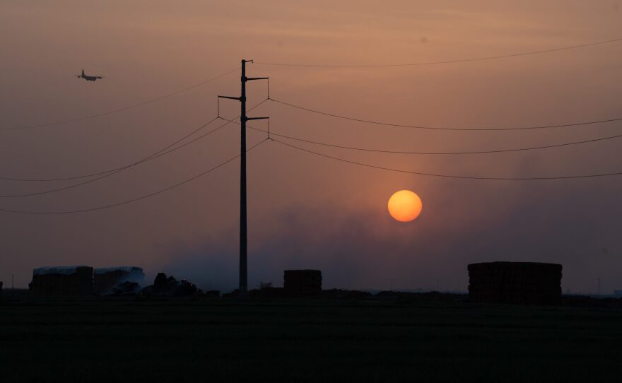 A fire burns near a field during a dust storm outside El Centro, Calif. on Aug. 6, 2024.