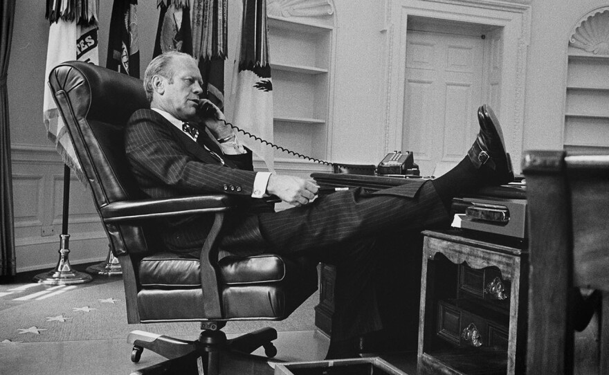 President Ford gets down to business in the Oval Office of the White House, recently emptied of President Nixon's personal effects, on August 12, 1974.