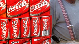 A heavyset man passes cartons of Coca-Cola displayed in a grocery store in Des Plaines, Illinois. 
