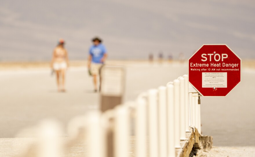 A sign warns of extreme heat danger in mid-June at the Badwater Basin in Death Valley, Calif.