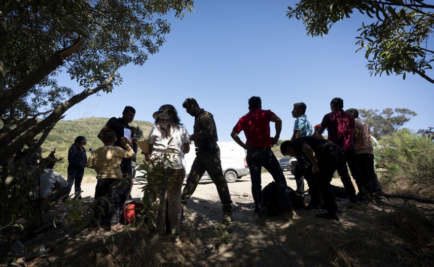 Border Patrol agents talk with migrants seeking asylum as they prepare them for transportation to be processed, Wednesday, June 5, 2024, near Dulzura, Calif. President Joe Biden on Tuesday unveiled plans to enact immediate significant restrictions on migrants seeking asylum at the U.S.-Mexico border as the White House tries to neutralize immigration as a political liability ahead of the November elections.