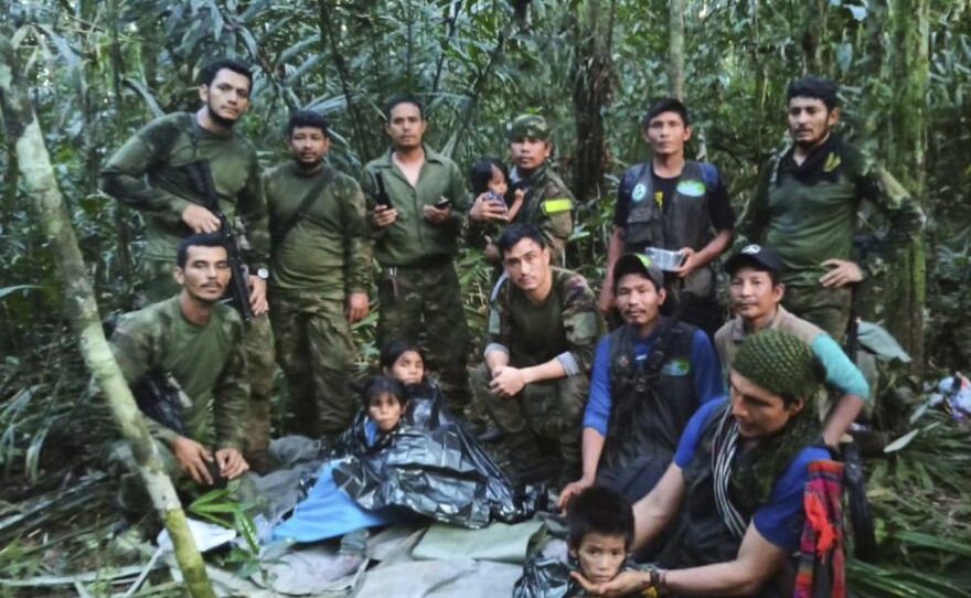 In this photo released by Colombia's Armed Forces Press Office, soldiers and others pose for a photo on Friday with the four children who were missing after a deadly plane crash in the Solano jungle, Caqueta state, Colombia.