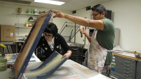 Tom Greyeyes works on a print at Arizona State University on Jan. 8 with the assistance of student, Emily Lewis. 