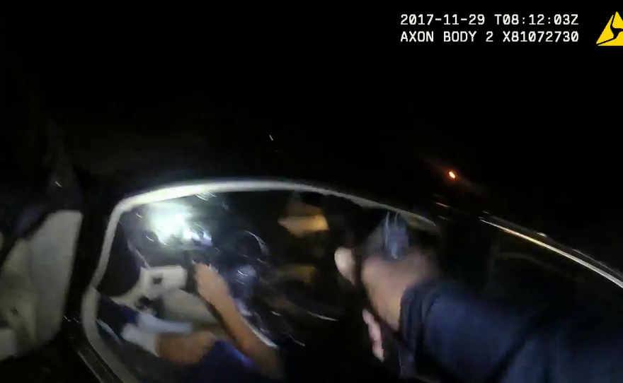 San Diego Police Officer Jarrell Davis prepares to shoot at a suspect as he drives his car away, Nov. 29, 2017.