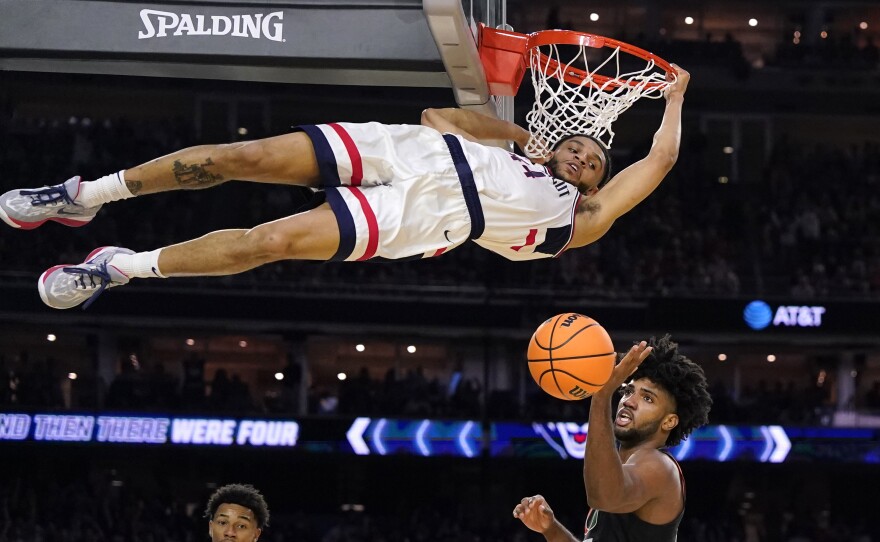 Connecticut guard Andre Jackson Jr. dunks the ball over Miami forward Norchad Omier, right, during the second half of a Final Four college basketball game in the NCAA Tournament on Saturday.