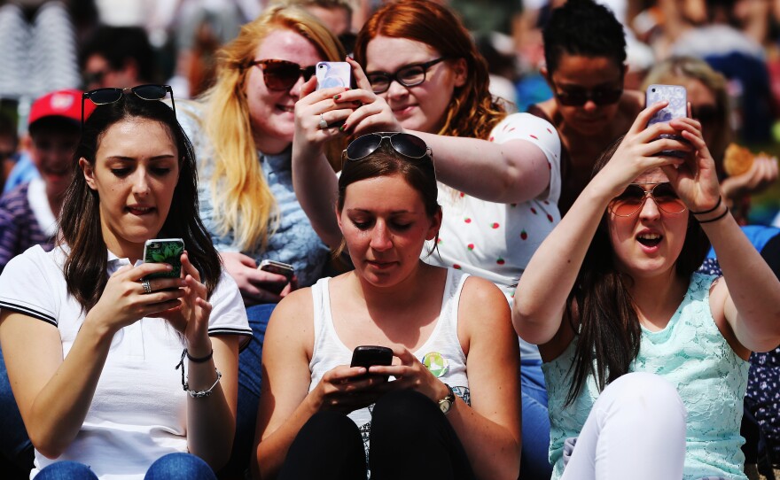 Tennis fans at this year's Wimbledon will have to take selfies the old-fashioned way, like these fans at last year's championships.