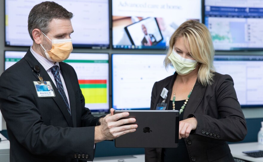 Dr. Michael Maniaci and Dr. Margaret Paulson confer at the Mayo Clinic's hospital-at-home command center in Jacksonville, Florida.
