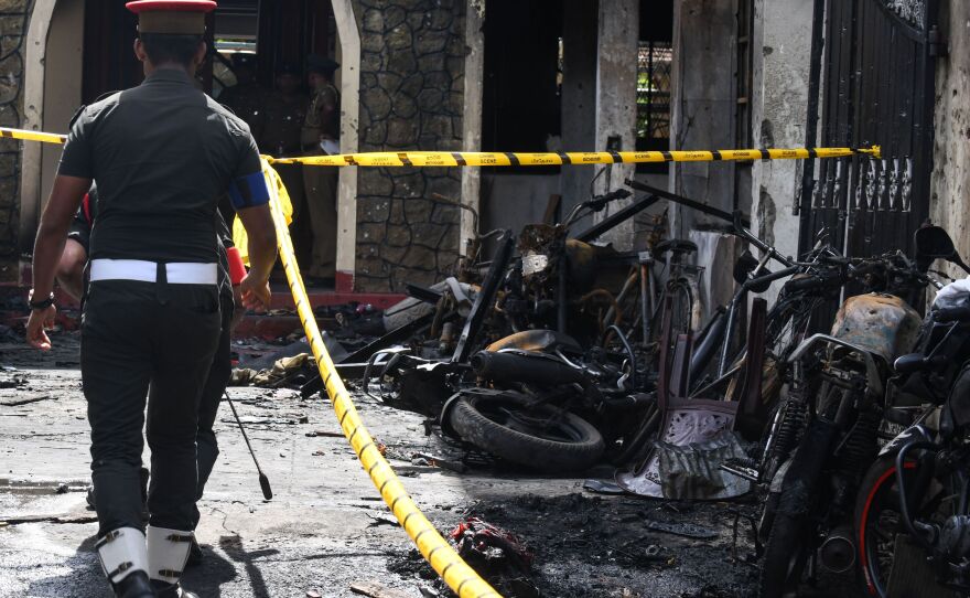 Security personnel walk past debris outside Zion Church in the eastern city of Batticaloa following the explosion at the church.