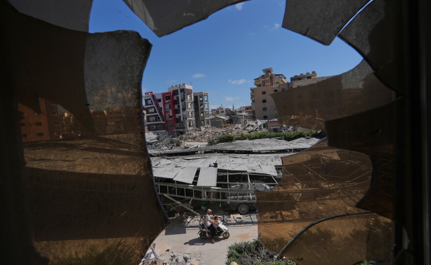 Buildings damaged by Israeli strikes are seen through shattered glass from the Jabal Amel Hospital in the southern port city of Tyre, Lebanon, Thursday, June 18, 2026.