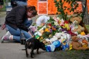 A woman cries as she lays down flowers in front of a house heavily damaged after a Russian strike on residential neighbourhood in Kyiv, Ukraine, on Friday, May 15, 2026.